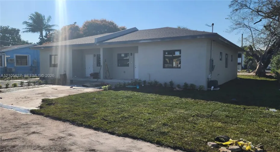 Single-story residence featuring a smooth stucco exterior, asphalt shingle roof, concrete driveway, and dark-frame windows