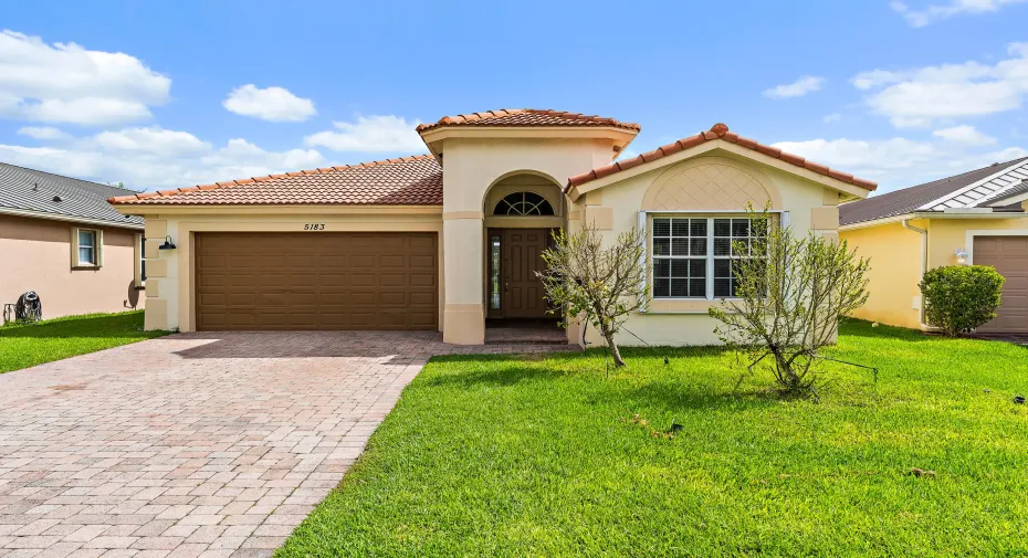 Welcome home to this Mediterranean-style home with classic Florida curb appeal: a barrel tile roof, an arched entry, and a wide paver driveway leading to a two-car garage. The lush green lawn and fresh landscaping make a great first impression, and accordion shutters on the windows mean storm prep takes minutes. Behind the front door, the views open to the pond and preserve.