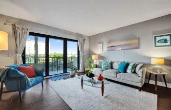 Living area featuring large-format tile flooring and expansive sliding glass doors opening to a private balcony