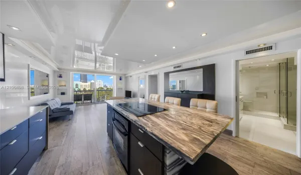 Kitchen featuring a stone-surface island with a built-in cooktop, high-gloss ceiling finish, wood-finish flooring, and recessed lighting