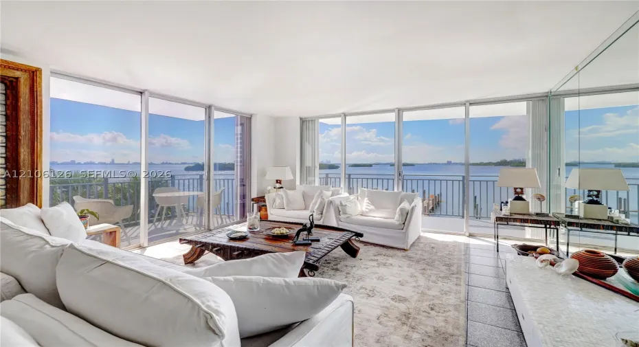 Floor-to-ceiling glass walls, expansive exterior terrace with metal railing, and neutral tile flooring