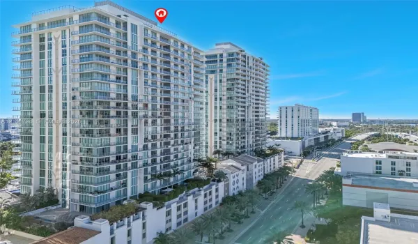 High-rise residential exterior featuring a glass-facade structure, private balconies, and landscaped podium terrace