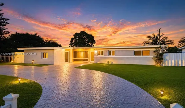 Single-story exterior featuring a stamped concrete driveway, exterior landscape lighting, and a fenced perimeter