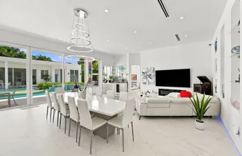 Sliding glass doors opening to outdoor living, recessed lighting, and a contemporary linear chandelier