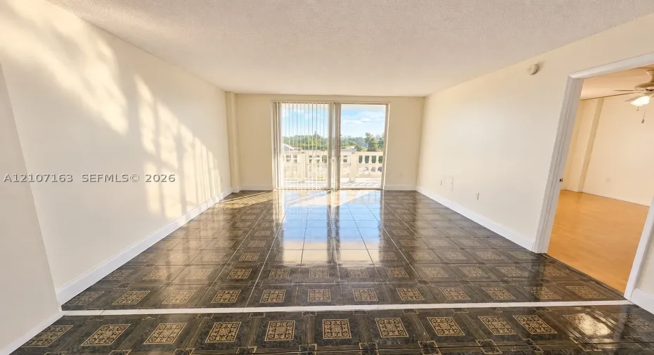 Interior space featuring patterned tile flooring and sliding glass doors leading to an exterior balcony