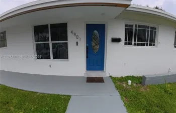 Exterior entry featuring a painted front door with an oval glass insert, multi-pane windows, a covered front porch, and a concrete walkway