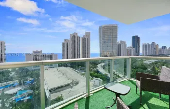 Private balcony featuring glass panel railing and cityscape and ocean horizon exposure