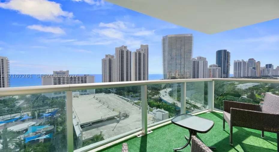 Private balcony featuring glass panel railing and cityscape and ocean horizon exposure