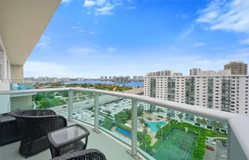 Elevated balcony featuring glass railings and panoramic water and urban scenery
