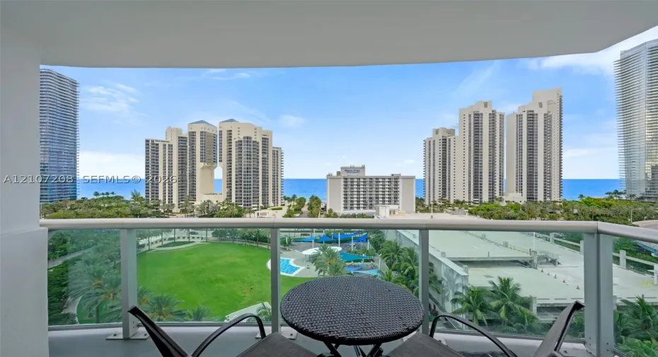 Covered balcony with glass panel railing and ocean scenery