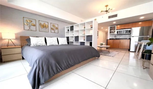Polished tile flooring, textured accent wall, and contemporary multi-arm ceiling lighting