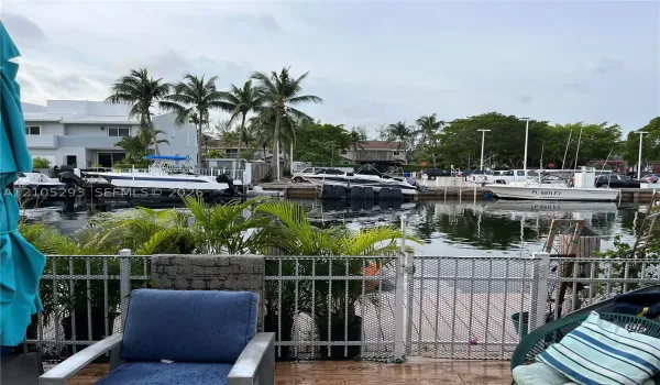 Waterfront property featuring a private boat slip, dockage with mooring posts, and metal perimeter fencing