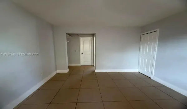 Ceramic tile flooring, neutral wall tones, and six-panel interior doors