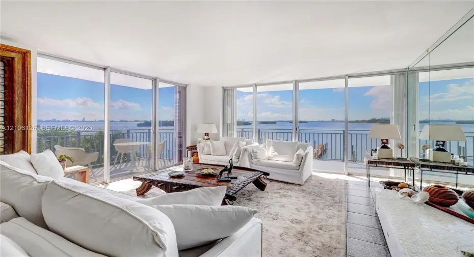 Floor-to-ceiling glass walls, expansive exterior terrace with metal railing, and neutral tile flooring