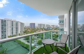 Covered balcony featuring glass pane railings and metal frame finish