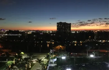 Panoramic city skyline featuring illuminated high-rise buildings and sunset horizon