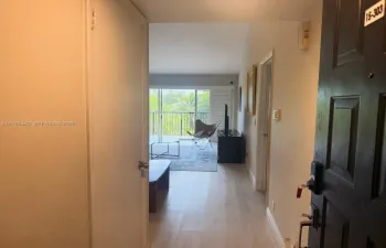 Entryway featuring wood-finish flooring, recessed door hardware, and an open layout with sliding glass doors leading to a balcony
