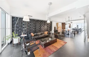 Textured black accent wall, large-format tile flooring, and integrated ceiling lighting fixtures