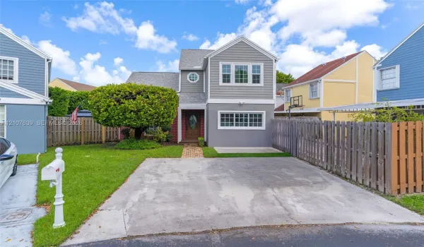 Multi-story residence with horizontal siding, brick masonry, asphalt shingle roofing, paved driveway, and manicured lawn