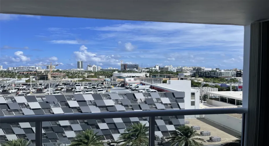 Private balcony featuring a metal railing and panoramic urban scenery