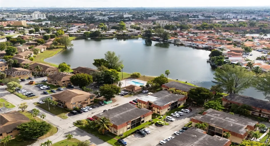 Aerial perspective of the community featuring a central lake and a shared swimming pool