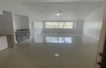 Vaulted ceilings, large-format tile flooring, built-in cabinetry, stone-surface counters, and oversized windows