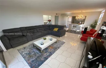 Open-concept interior featuring light-toned tile flooring, recessed ceiling lighting, and a chandelier-style fixture
