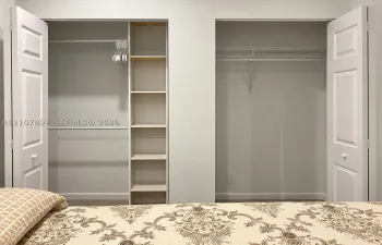 Dual reach-in closets featuring white paneled bifold doors, integrated shelving, and white wire rack systems