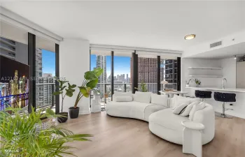 Floor-to-ceiling windows, wood-finish flooring, built-in kitchen breakfast bar, and open-concept layout