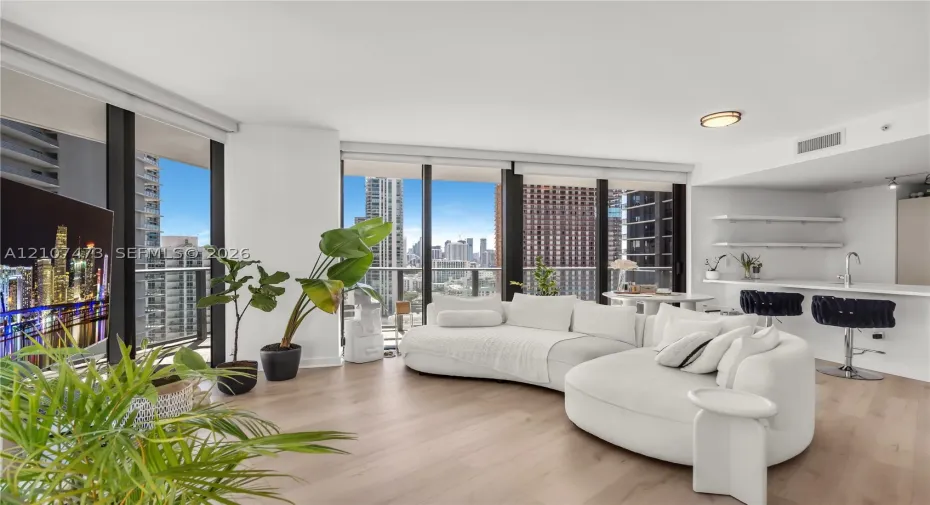 Floor-to-ceiling windows, wood-finish flooring, built-in kitchen breakfast bar, and open-concept layout