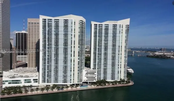 High-rise residential towers featuring glass facades, multiple balconies, and a waterfront location