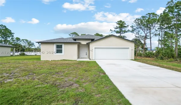 Single-story residence with a stucco exterior, asphalt shingle roof, two-car garage, and concrete driveway