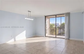 Ceramic tile flooring, crown molding, multi-light linear chandelier, and sliding glass door with access to a screened balcony
