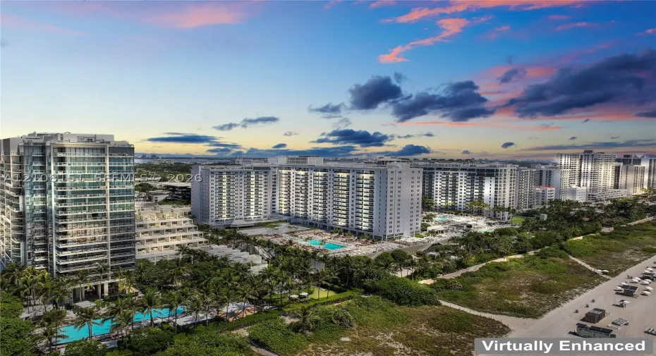 High-rise residential complex featuring swimming pools, sun decks, landscaped grounds, and immediate proximity to the coastline