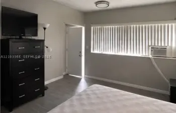 Neutral wall finishes, wood-finish flooring, and a flush-mount ceiling light fixture