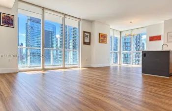 Floor-to-ceiling windows, wood-finish flooring, and kitchen island with a built-in sink