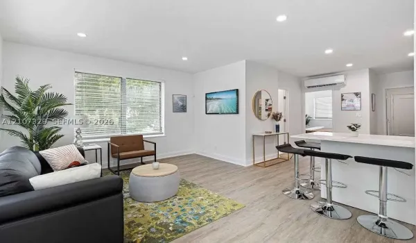 Open-concept living room with modern kitchen and wood-look flooring.