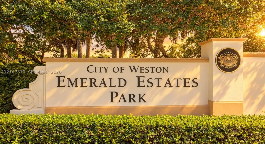 Stucco monument sign featuring raised lettering, integrated decorative medallion, and professional landscaping