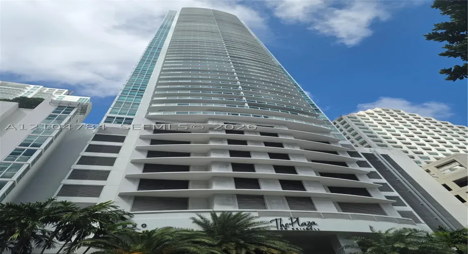 High-rise architectural structure featuring a glass-curtain facade, integrated wraparound balconies, and reinforced concrete exterior pillars