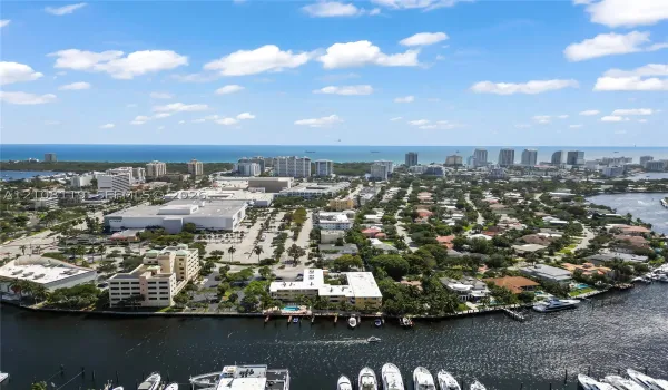 Aerial perspective featuring coastal proximity, deep-water canal access, private boat slips, and dense canopy of mature trees