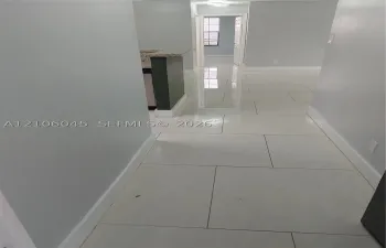 Large-format polished tile flooring featuring a neutral finish and a peninsula with a stone-composite countertop