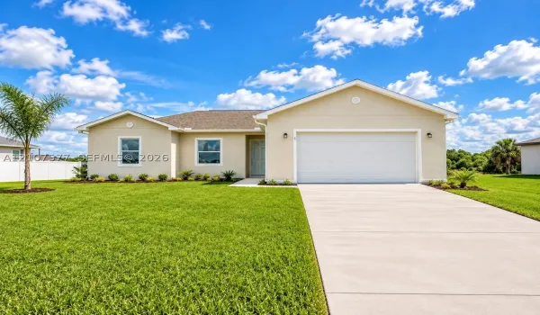 Single-story exterior featuring light-toned stucco siding, a gabled roof, an attached two-car garage, and a concrete​​‌​​​​‌​​‌‌​‌‌​​​‌‌​‌​‌​‌​​​‌​​ driveway