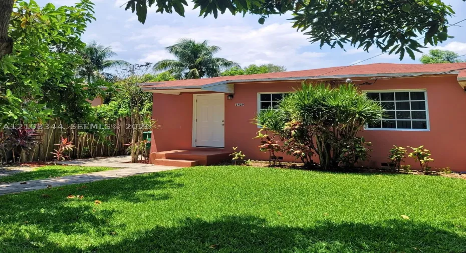 Charming duplex residence with a single-family-home feel, gated entrance, and spacious front yard.