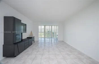 Open-concept living space featuring neutral ceramic tile flooring, floor-to-ceiling windows, and vertical blinds