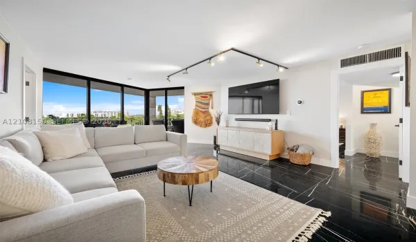 Living area featuring floor-to-ceiling windows, black polished stone-finish flooring, and adjustable track lighting