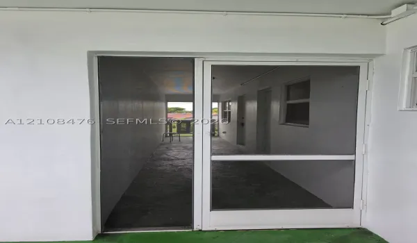 White aluminum frame screen door featuring a glass-inset panel and secure latch hardware