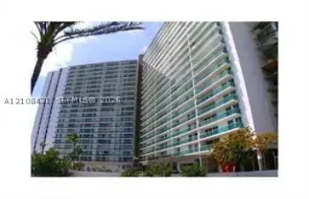 High-rise residential exterior featuring expansive glass-railed balconies and floor-to-ceiling windows