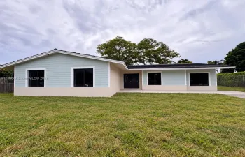 Single-story residence featuring light-toned horizontal siding, a stucco exterior finish, dark-frame windows, and a concrete driveway