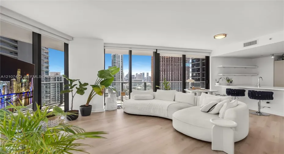 Floor-to-ceiling windows, wood-finish flooring, built-in kitchen breakfast bar, and open-concept layout