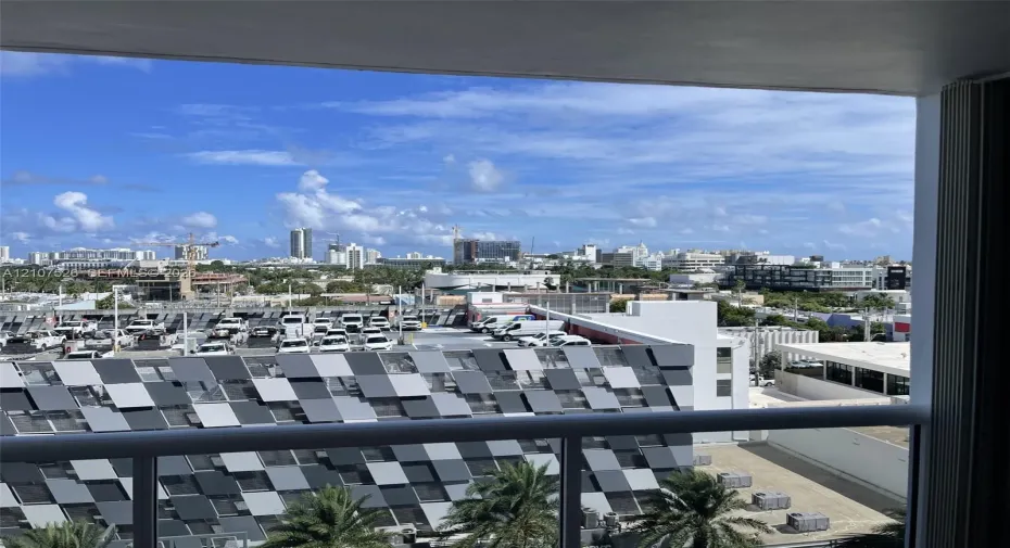 Private balcony featuring a metal railing and panoramic urban scenery